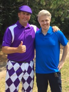 Community event organizer posing at golf tournament with Dr. David Taylor